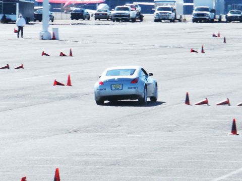 2001 Mercury Grand Marquis - A silver coupe navigates a course marked by traffic cones, with other vehicles visible in the background.