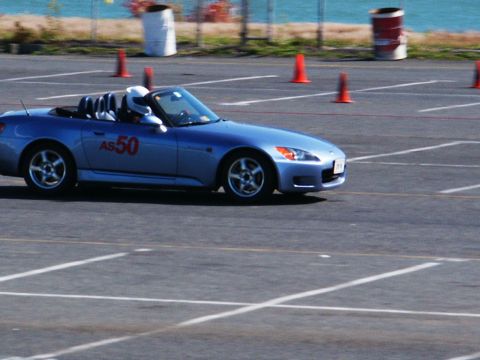 2001 Mercury Grand Marquis - A blue convertible sports car with racing number AS50 navigates a course marked by orange cones on a sunny day.
