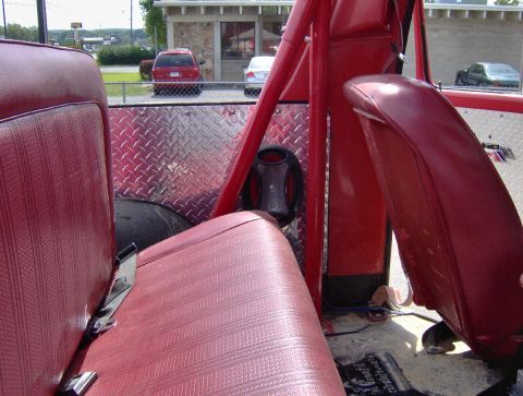 1978 Ford Bronco - Interior view of a vehicle showing red seats and diamond plate accents on the rear panel.