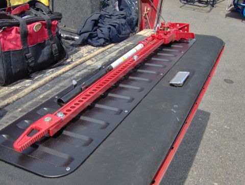 1978 Ford Bronco - A red hi-lift jack and a red and black tool bag are placed on the bed of a red truck.