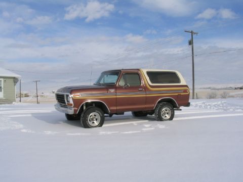1979 Ford Bronco - A classic Ford Bronco sits in a snowy landscape under a partly cloudy sky.