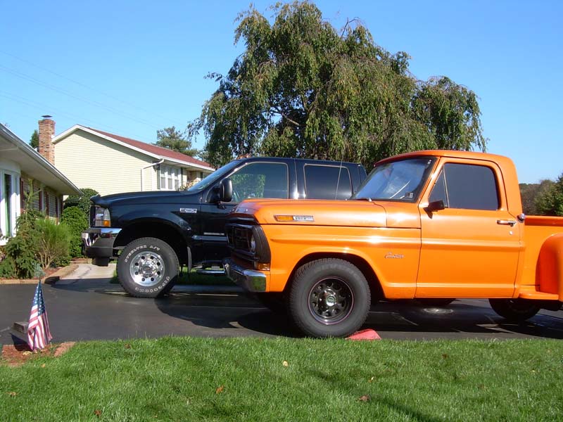 Orange Ford pickup and black Ford Super Duty parked in a driveway