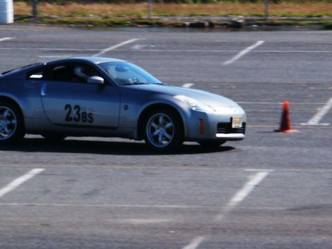 2001 Mercury Grand Marquis - A silver sports car with the number 23BS on its side navigates a course marked by cones and painted lines.