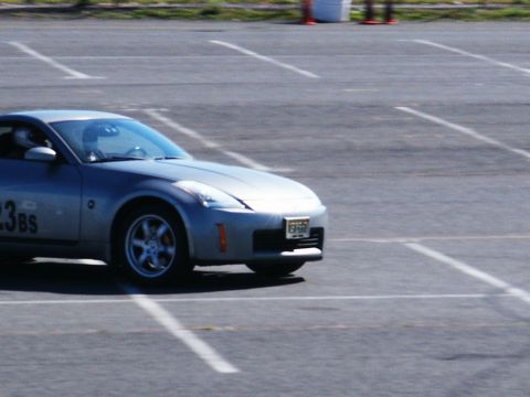 2001 Mercury Grand Marquis - Silver Nissan 350Z with racing numbers on the door is seen on a paved lot.