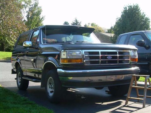 1992 Ford Bronco - Front view of a black Ford Bronco parked on a driveway with a wooden step stool nearby.