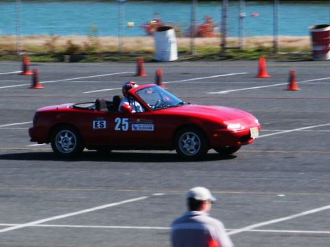 2001 Mercury Grand Marquis - A red convertible sports car, identified by racing number 25, navigates a course marked by orange cones.