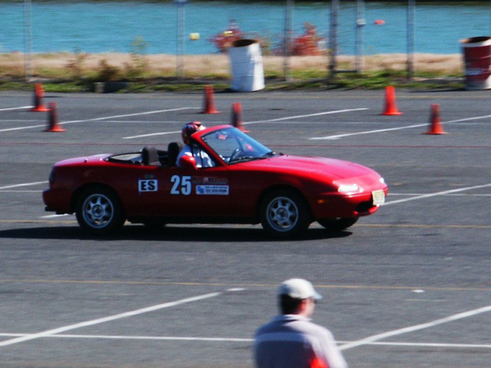 Red convertible sports car with racing number 25 on its side, on a race track