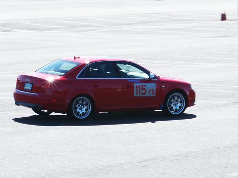 2001 Mercury Grand Marquis - A red sedan with racing numbers is seen on a paved surface, possibly a track.