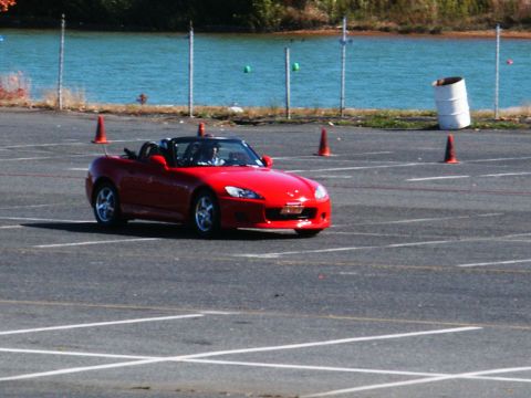 2001 Mercury Grand Marquis - A red convertible sports car navigates a course marked by orange cones.