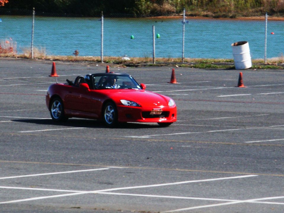 Red convertible sports car on a track with orange cones