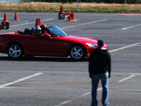 2001 Mercury Grand Marquis - A red convertible sports car navigates a course marked by orange cones.