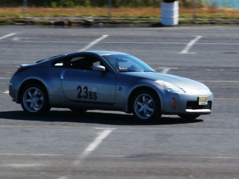 2001 Mercury Grand Marquis - A silver Nissan 350Z is captured on a race track, displaying the number 23BS on its door.