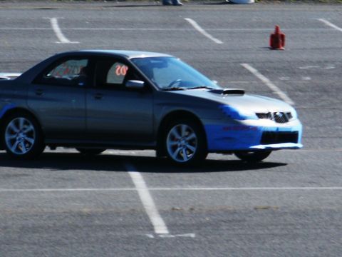 2001 Mercury Grand Marquis - A silver Subaru Impreza WRX with a hood scoop and blue tape on its front bumper is seen on a track.