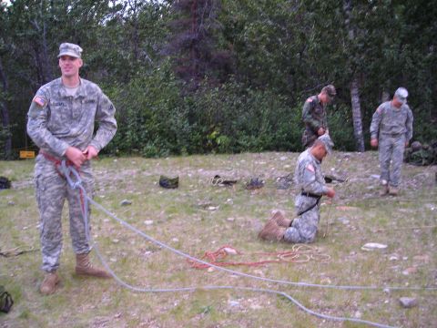 2003 Jeep TJ - Several soldiers are gathered outdoors, handling ropes and equipment.