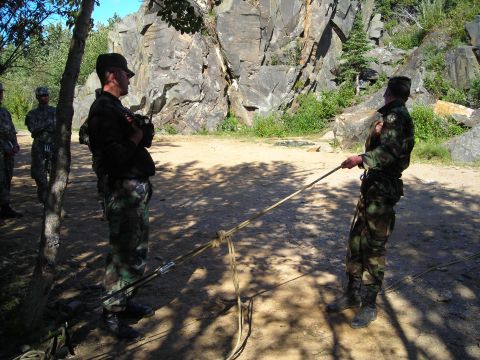 2003 Jeep TJ - Soldiers train for a rope rescue operation, with a rocky cliff and trees forming the backdrop.