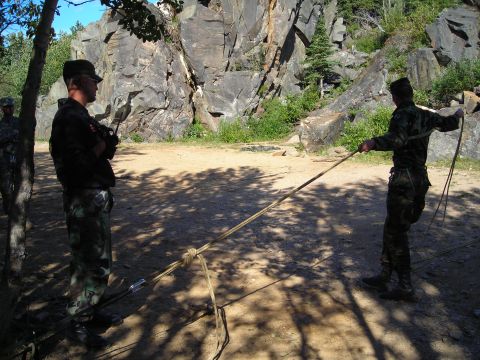 2003 Jeep TJ - Military personnel practice with rope in a rocky outdoor environment.