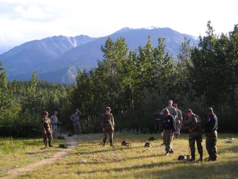 2003 Jeep TJ - A group of soldiers are gathered outdoors in a scenic mountainous area.