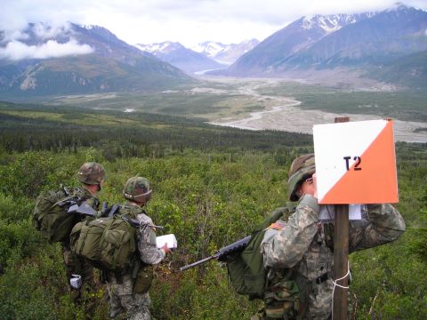 2003 Jeep TJ - Three soldiers navigate a mountainous terrain using an orienteering marker and maps.