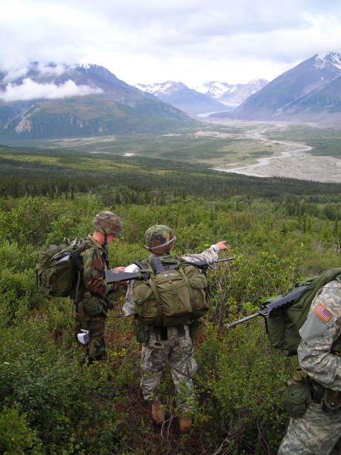 2003 Jeep TJ - Two soldiers consult a map while another points towards a distant valley in a , mountainous environment.