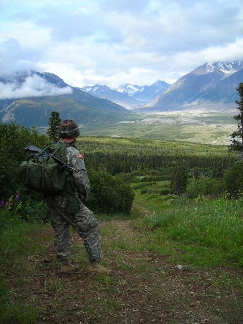 2003 Jeep TJ - A soldier surveys a vast, green valley surrounded by , cloud-shrouded mountains.