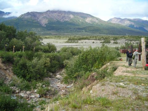 2003 Jeep TJ - A wide shot captures a vast natural landscape with mountains in the background and a group of individuals in the foreground.