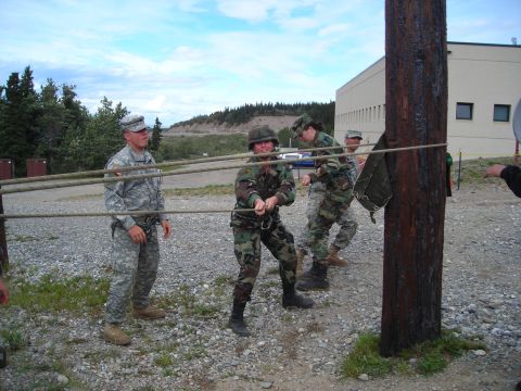 2003 Jeep TJ - Military personnel participate in a rope-pulling exercise around a wooden pole.