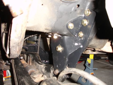 1996 Ford Bronco - Close-up view of a suspension lift bracket being installed on a vehicle's frame.