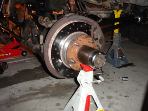1996 Ford Bronco - Close-up of a vehicle's suspension and brake components, supported by jack stands.