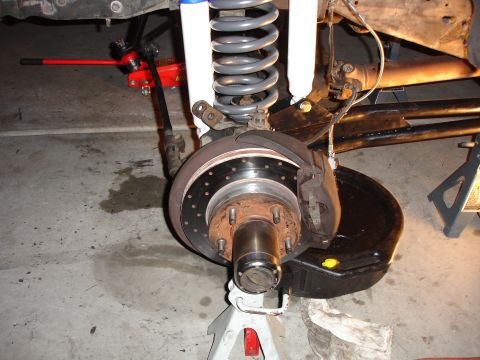 1996 Ford Bronco - Front suspension and brake assembly on jack stands during maintenance or repair.