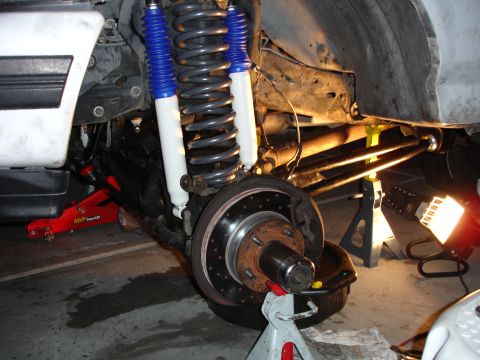 1996 Ford Bronco - Close-up view of a vehicle's suspension system during a lift installation, showing new shocks and springs.