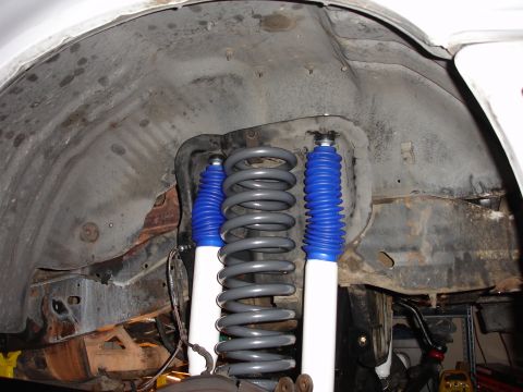 1996 Ford Bronco - Close-up view of suspension components within a vehicle's wheel well.