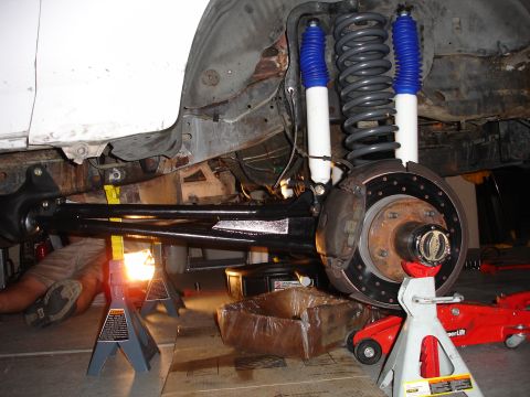 1996 Ford Bronco - Front suspension and brake components of a 1996 Ford Bronco during a lift installation.