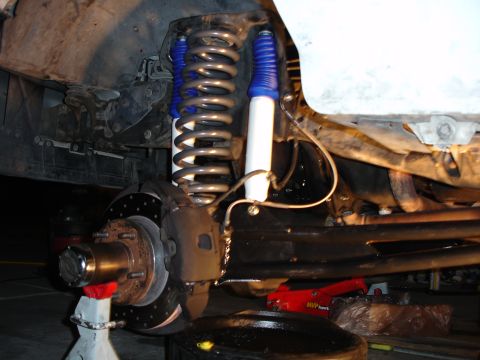 1996 Ford Bronco - Front suspension of a 1996 Ford Bronco showing new shocks with blue boots and upgraded coil springs.