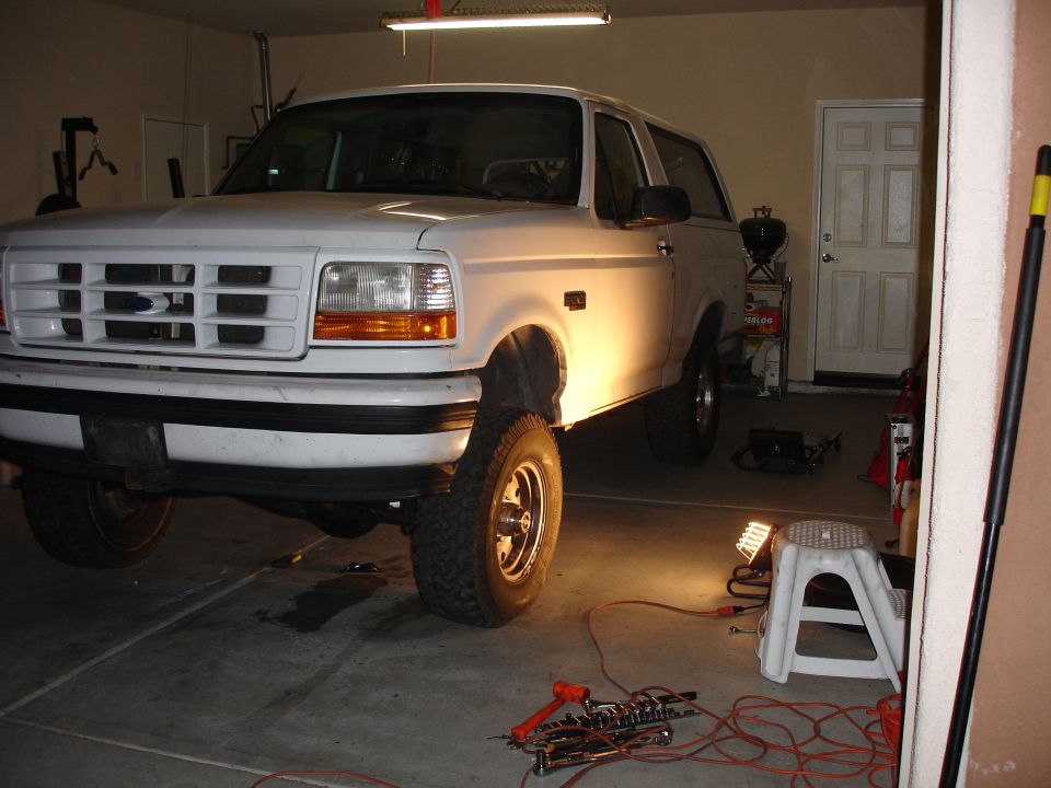 1996 Ford Bronco parked in a garage with tools on the floor