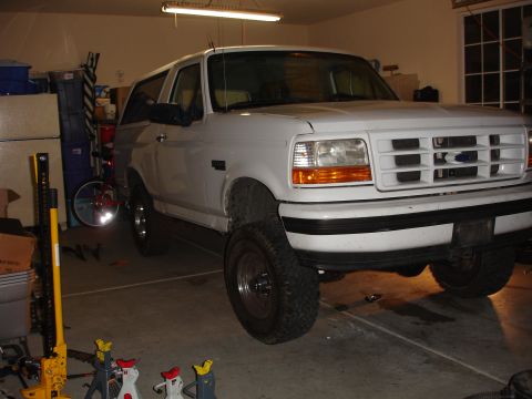 1996 Ford Bronco - A white 1996 Ford Bronco is shown in a garage, possibly undergoing a lift installation.