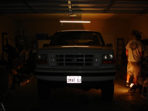 1996 Ford Bronco - A white Ford F-Series truck is parked inside a garage with a person standing to the right.