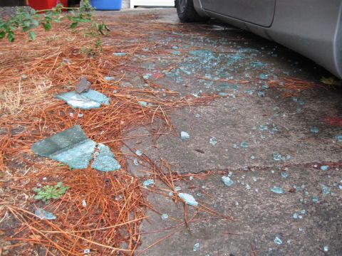 1994 Ford Probe - Shattered glass litters the ground next to a car's side door.