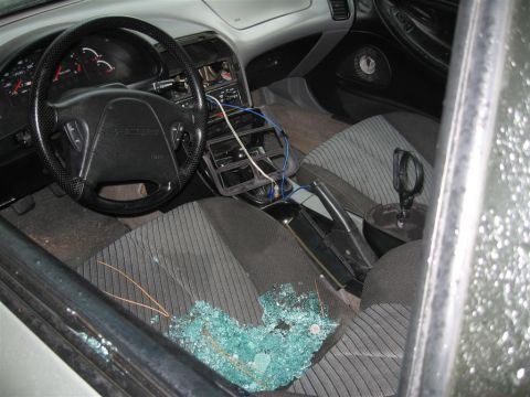 1994 Ford Probe - The interior of a car shows shattered glass on the passenger seat and floor, indicating a break-in.