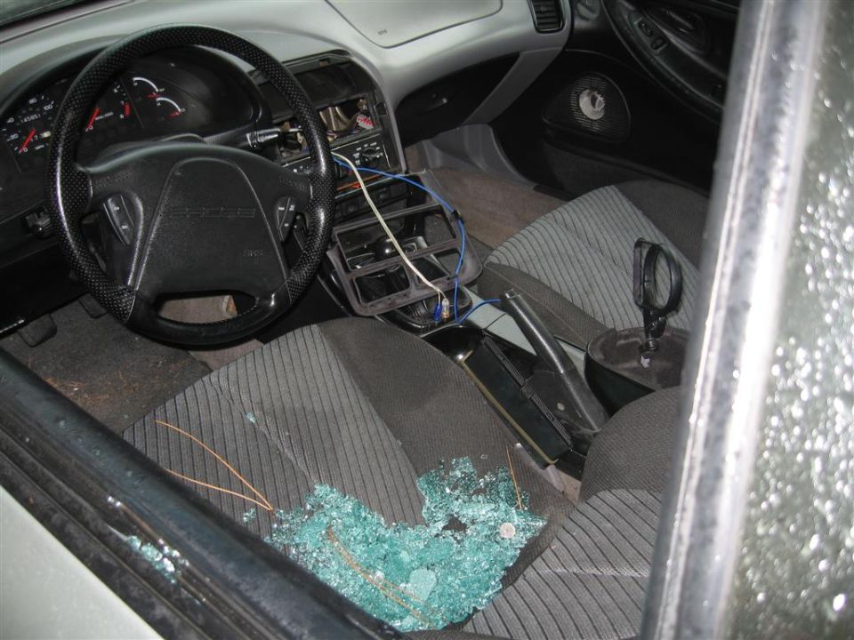 Interior view of car with broken glass on passenger seat and dashboard