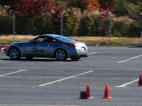 2001 Mercury Grand Marquis - Silver Nissan 350Z navigates a course marked by cones on a paved track.