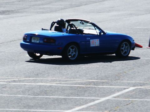 2001 Mercury Grand Marquis - A blue convertible sports car is seen on a paved track, possibly during a racing event.