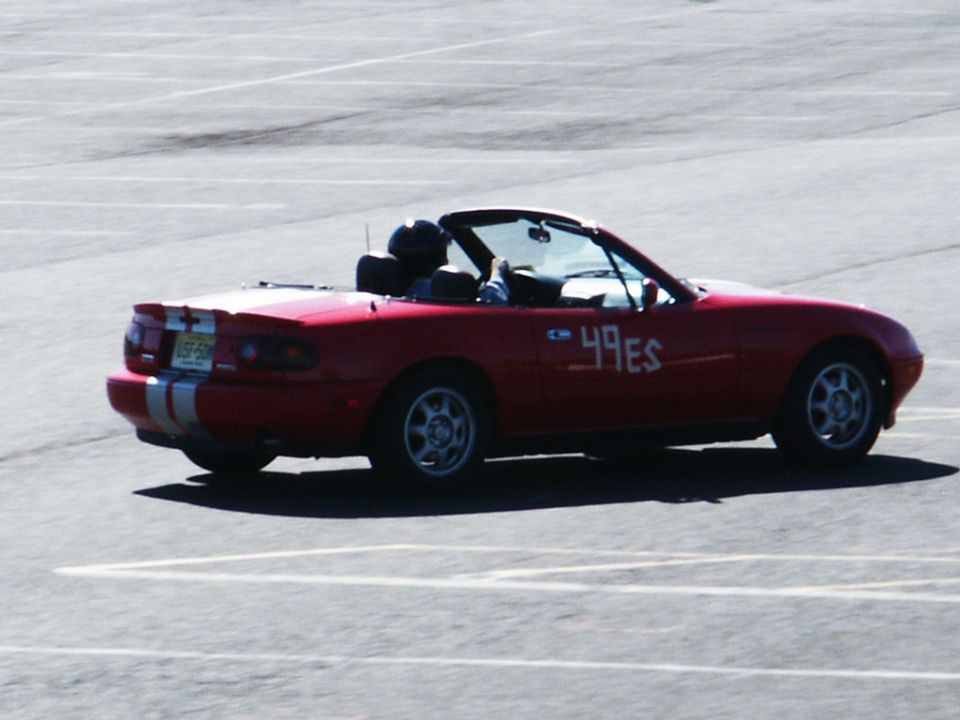 Red convertible with racing numbers '49ES' on the side and racing stripes on the trunk