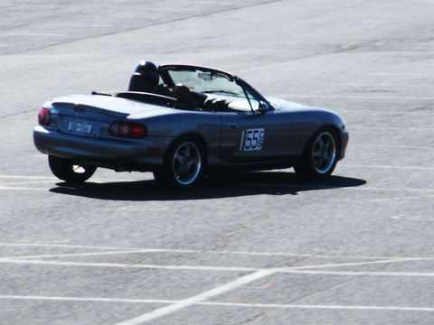 2001 Mercury Grand Marquis - A silver convertible sports car, identified by racing number 155, is seen on a paved surface, likely a track.