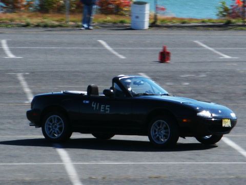 2001 Mercury Grand Marquis - A black convertible with racing numbers is seen on a track with orange cones in the background.