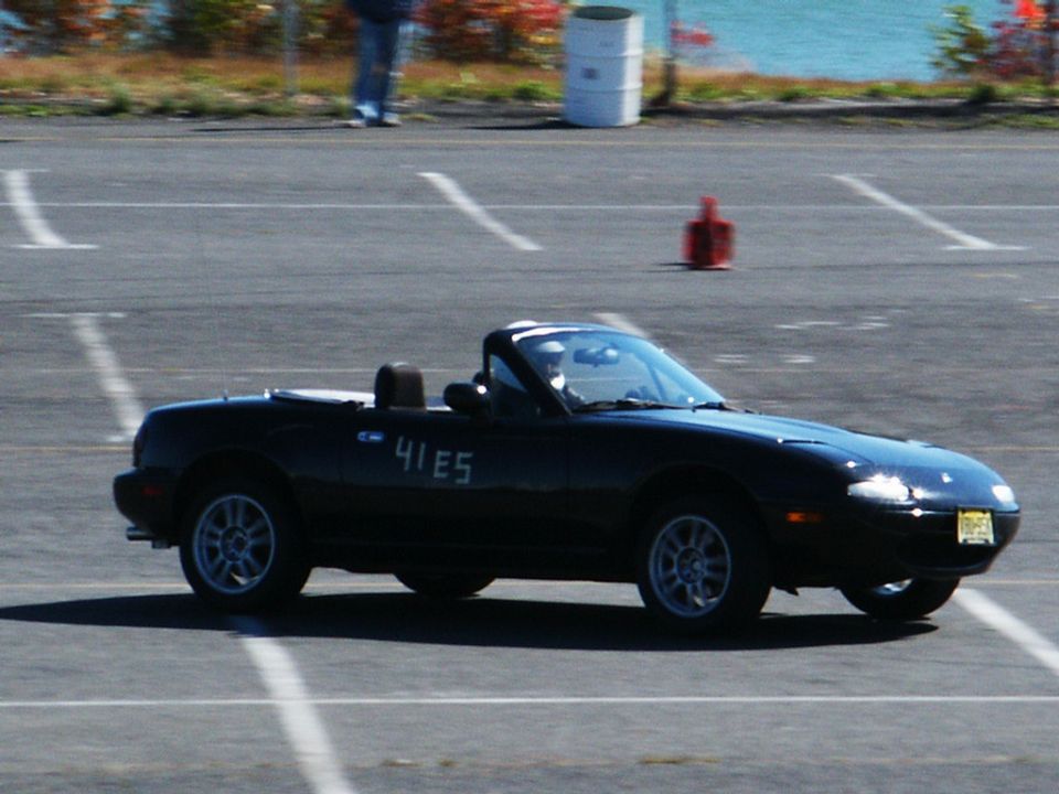 Black convertible sports car with "41 E5" on the side, driving on a paved lot