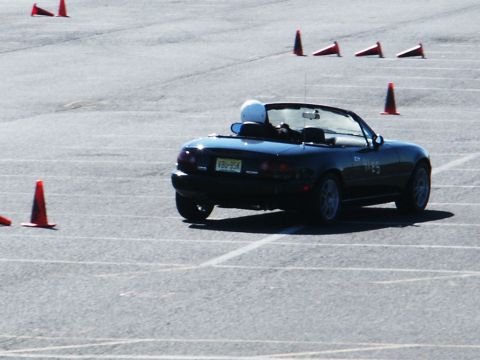 2001 Mercury Grand Marquis - A dark convertible sports car navigates a course marked by orange cones on a paved surface.