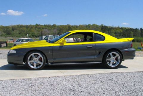 1995 Ford Mustang - This two-tone gray and yellow coupe has a distinctive hood scoop and aftermarket wheels.
