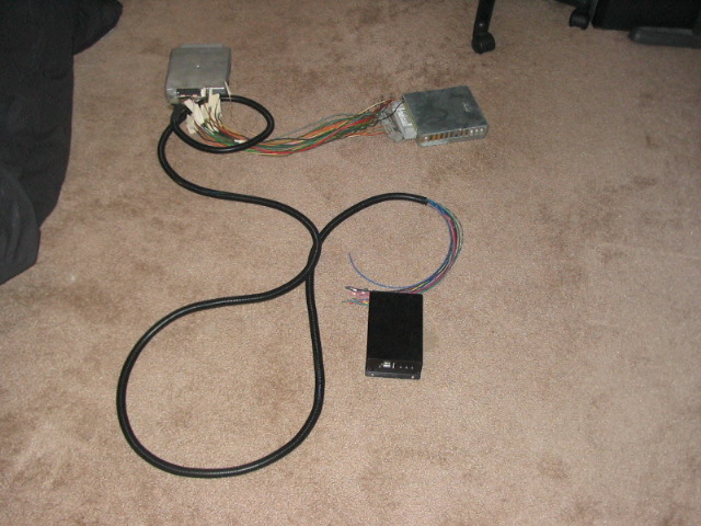 Two engine control units connected by a wiring harness, with a small black box
