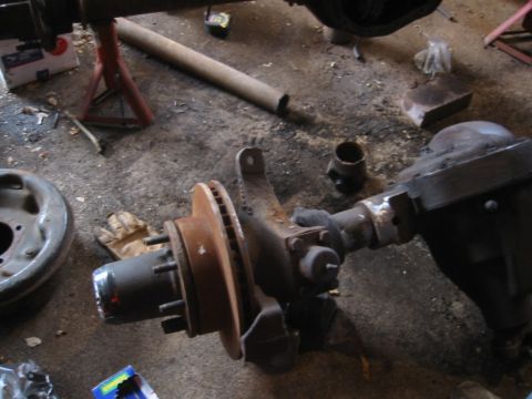 1995 Ford Bronco - A disassembled front axle assembly with brake components is visible on a workshop floor.