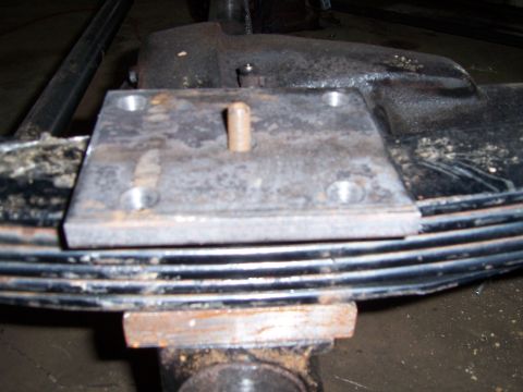 1983 Ford Bronco - Close-up of a leaf spring assembly with a custom metal plate modification. Text at bottom reads SUPERMOTORS.NET.